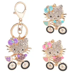 Chaton en cristal sur un vélo - porte-clés